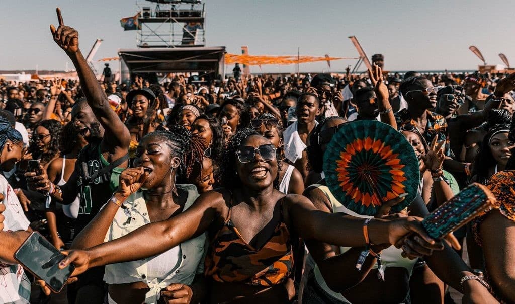 Crowd cheering at an outdoor music festival in Ghana